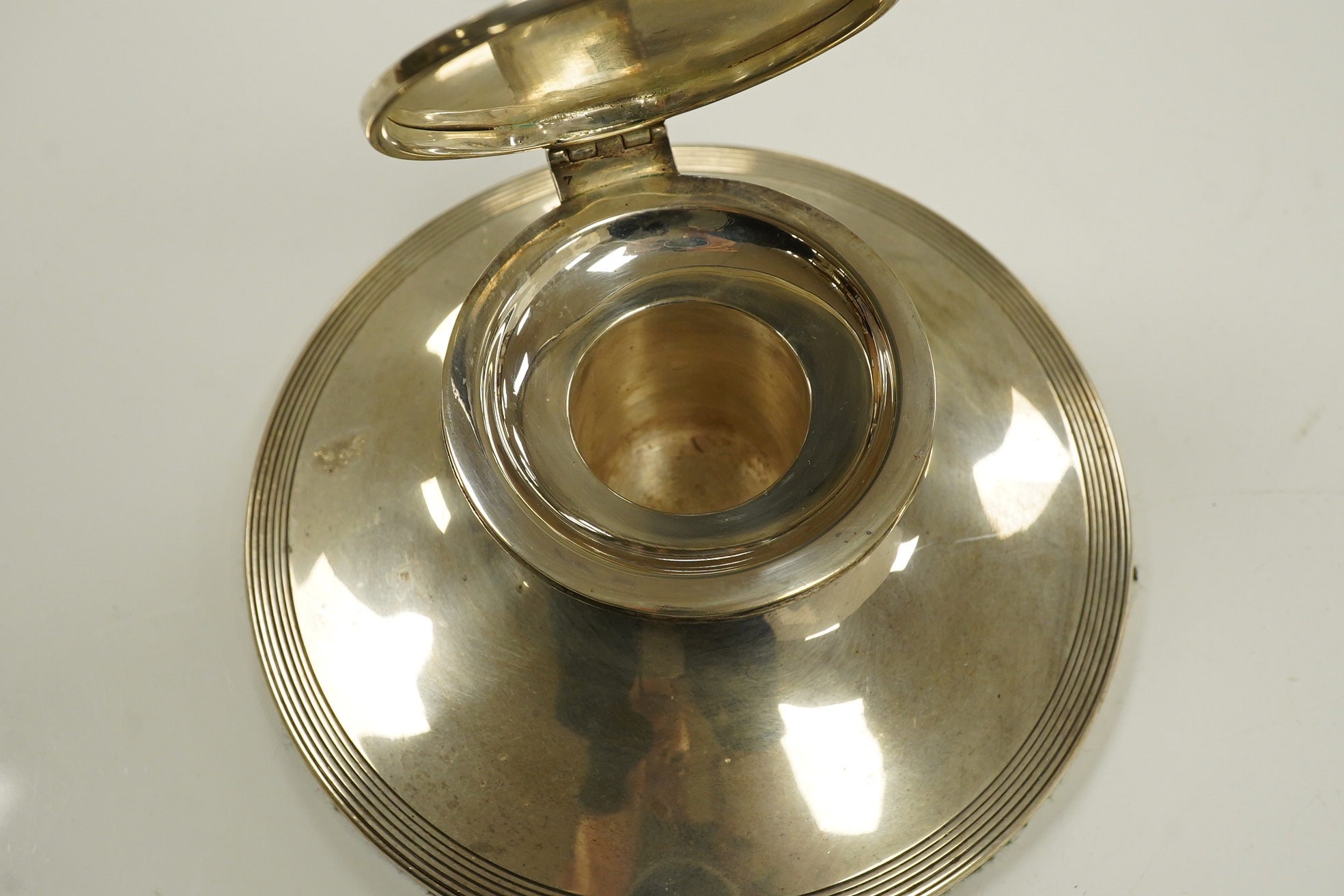 A George V reeded silver capstan inkwell with loaded base, 15cm diameter. Condition - good